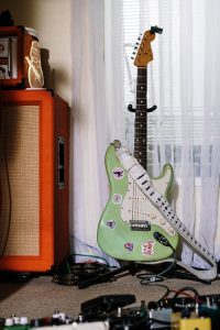 Stylish electric guitar with amp and equipment in a cozy home studio setting.